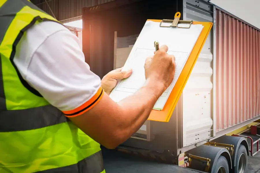 Técnico realizando inspeção de um caminhão através de um check list de veículos em papel